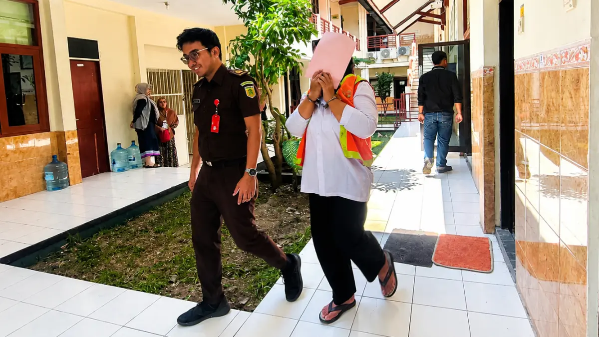 TUTUPI WAJAH : Elis di Pengadilan Negeri Lamongan. Dia cekcok dengan tetangganya berujung pelemparan batu. (Ahmad Asip/Radar Lamongan) 