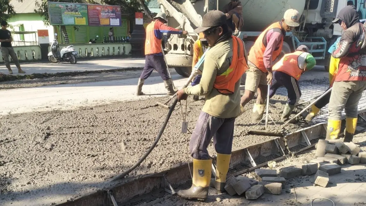 DIPERKIRAKAN AKHIR BULAN INI SELESAI: Pekerja masih mengerjakan proyek jalan Tikung — Kembangbahu. (Gamal A/Radar Lamongan) 
