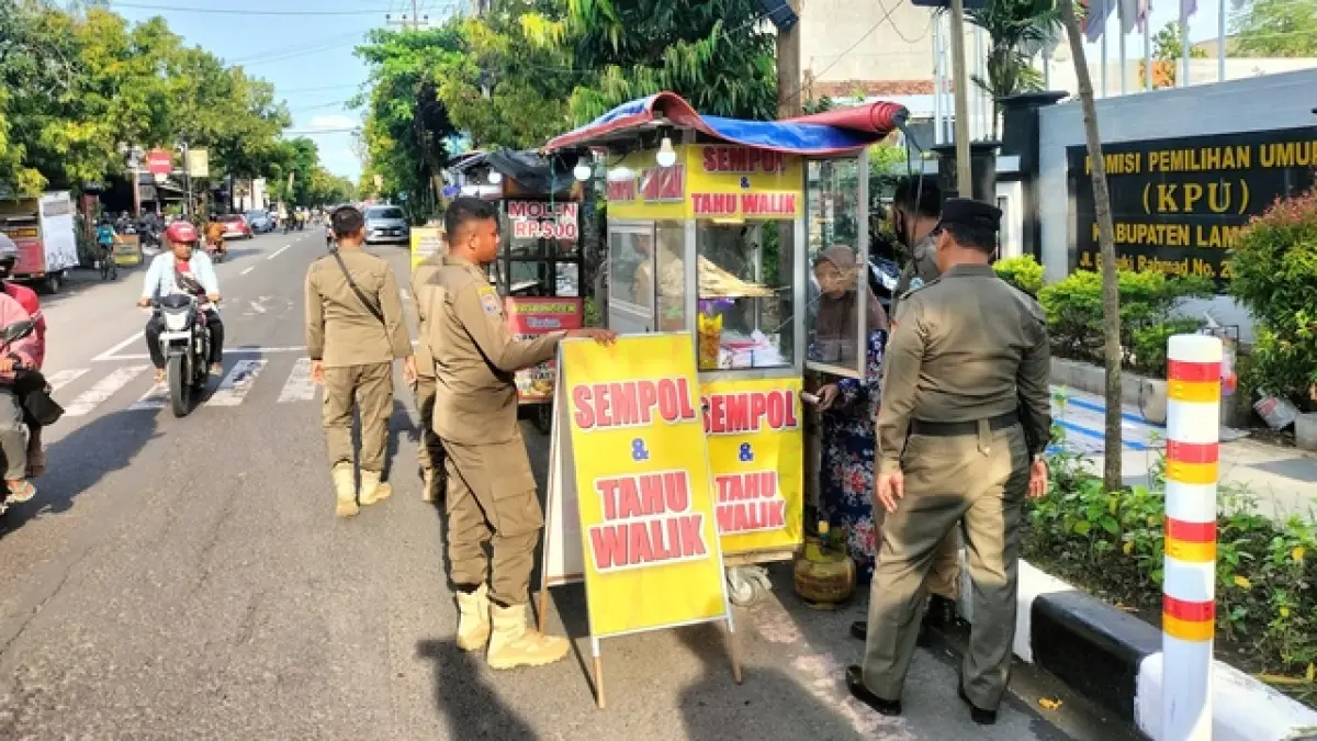 DILARANG DI BAHU JALAN: PKL di Jalan Basuki Rahmad Lamongan ditertibkan petugas Satpol PP.&nbsp;(Istimewa/Radar Lamongan) 
