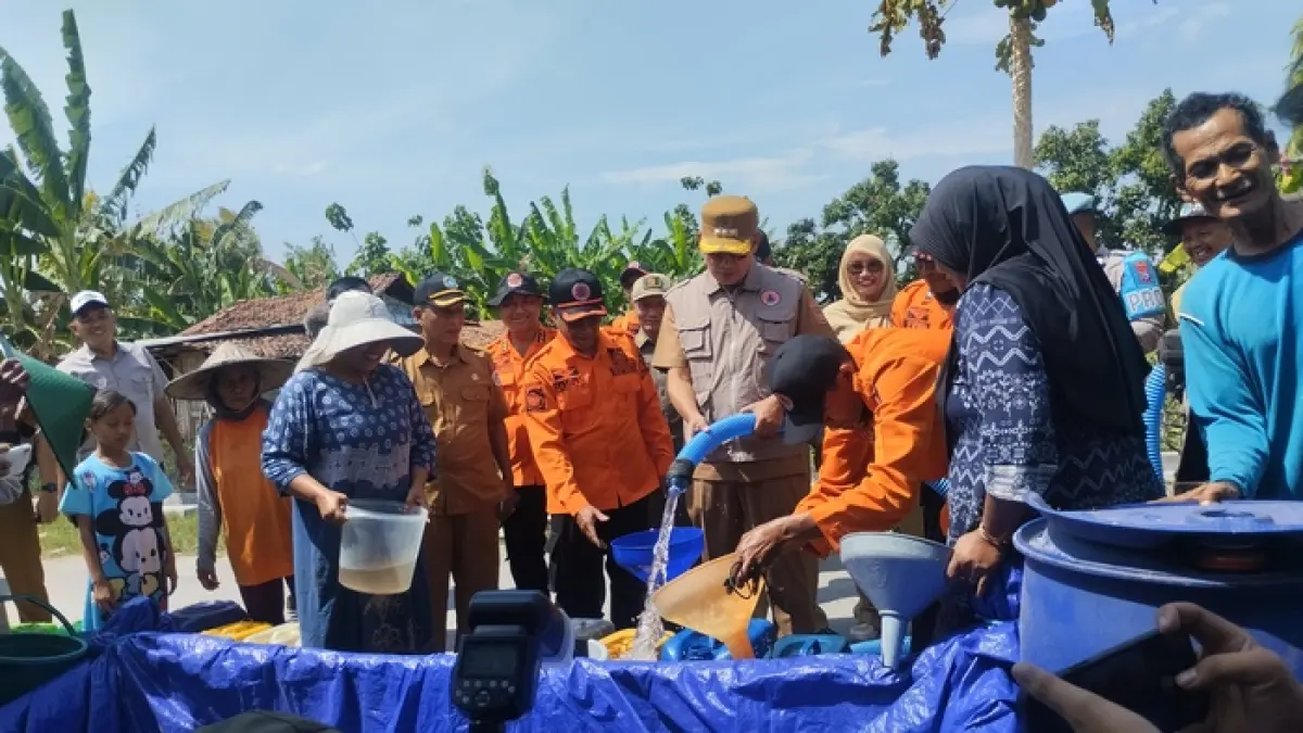 SALURKAN BANTUAN AIR BERSIH: Bupati Yes memegang pipa saluran dari tangki untuk bantuan air bersih bagi masyarakat di Dusun Walangkopo, Desa Kedungkumpul, Kecamatan Sarirejo.&nbsp;(Humas Kominfo/Radar Lamongan) 