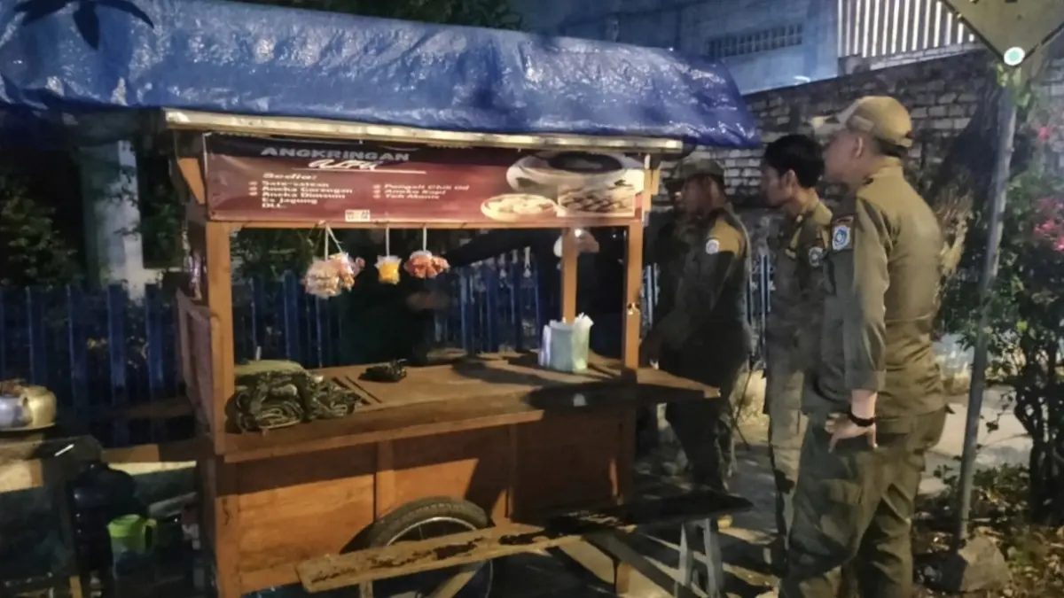 Petugas Satpol PP Lamongan saat memberikan peringatan kepada salah satu pedagang yang berjualan di pinggir Jalan Basuki Rahmad Lamongan. (GAMAL AYATULLAH/RADAR LAMONGAN)