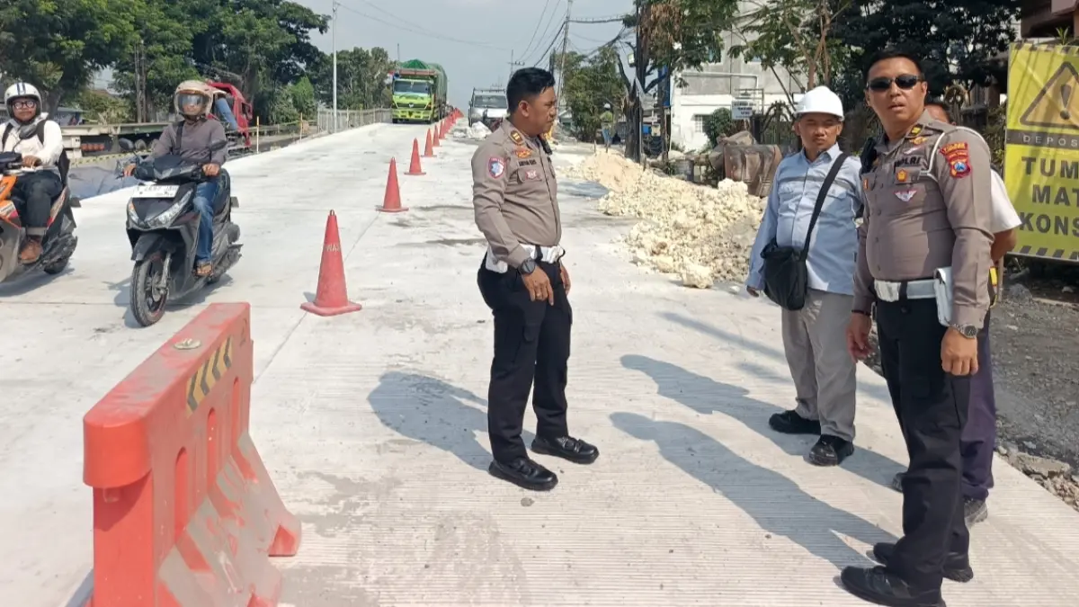 Petugas Satlantas Polres Lamongan melakukan pengaturan lalin, usai jembatan Desa Kesambi sisi utara mulai dibuka kembali setelah perbaikan. (ISTIMEWA/RADAR LAMONGAN)