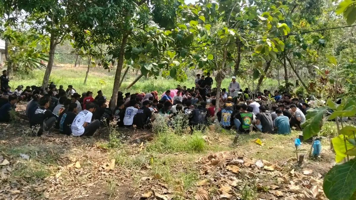 BERDUKA: Rekan — rekan seperguruan dan warga setempat yang menghadiri pemakaman Aj kemarin.&nbsp;(Gamal A/Radar Lamongan) 