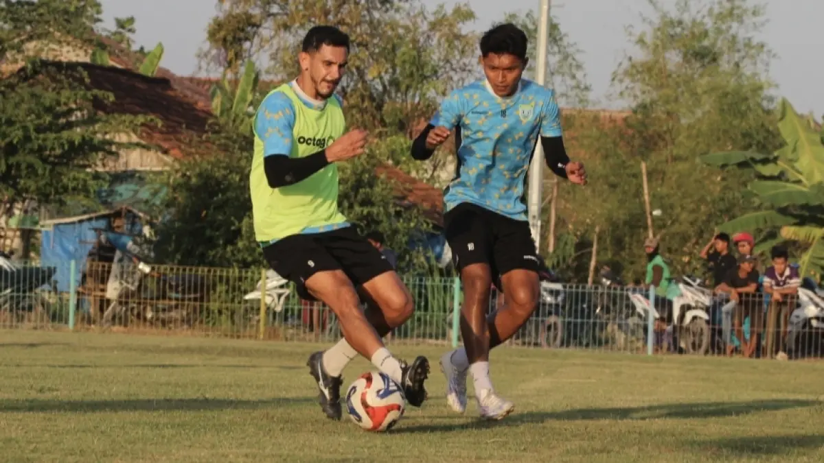 Juninho Cabral berebut bola dengan Indra Riyanto dalam sesi latihan Persela di Lapangan Kendalkemlagi, Kecamatan Karanggeneng. (AHMAD ASIP/RADAR LAMONGAN)