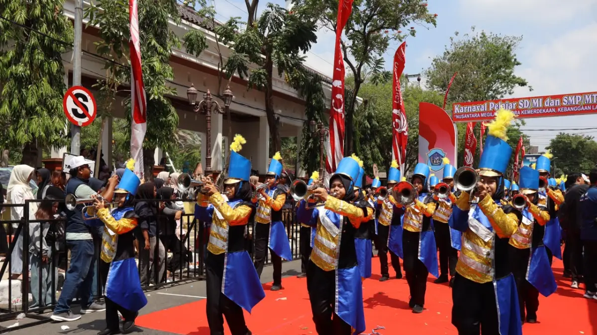Pasukan drumband kebanggaan SMPN 4 Lamongan, Gita Pena Swara tampil menghibur dalam Megkarnaval 2026. (AHMAD ASIP/RADAR LAMONGAN)
