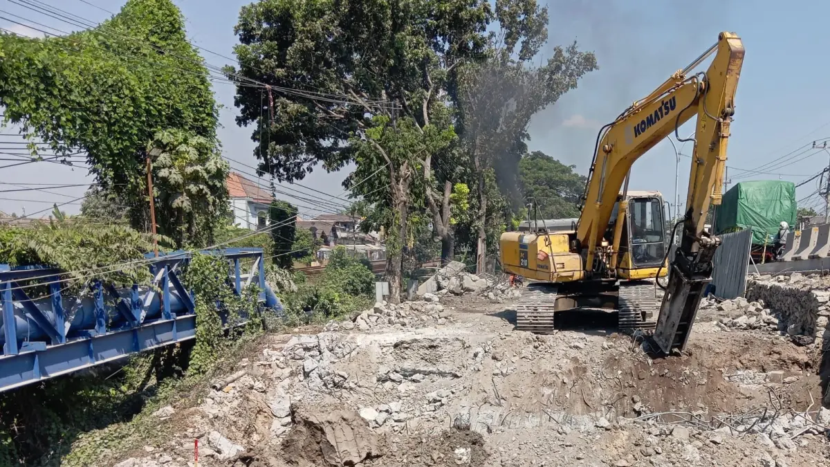 Alat berat dikerahkan untuk menuntaskan pembongkaran sisi selatan jembatan di Desa Kesambi. (ISTIMEWA/RADAR LAMONGAN)