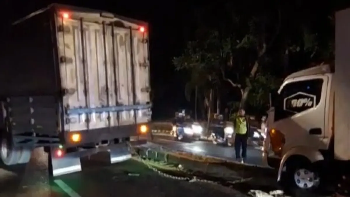 DIEVAKUASI: Truk yang naik ke median jalan ditarik truk lain agar arus lalu lintas kembali lancar.&nbsp;(Gamal A/Radar Lamongan)