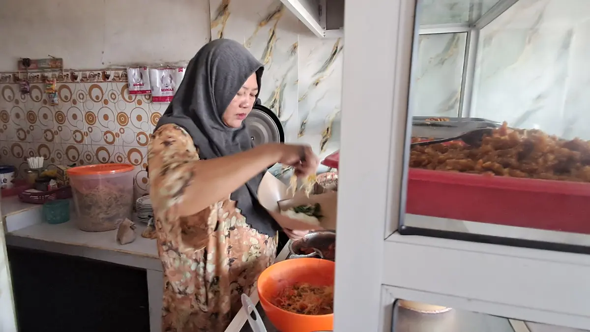 RASA PEDAS: Rohma berjualan nasi pecel dengan khas rasa pedasnya di Jalan Mastrip Lamongan. (Gamal A/Radar Lamongan)