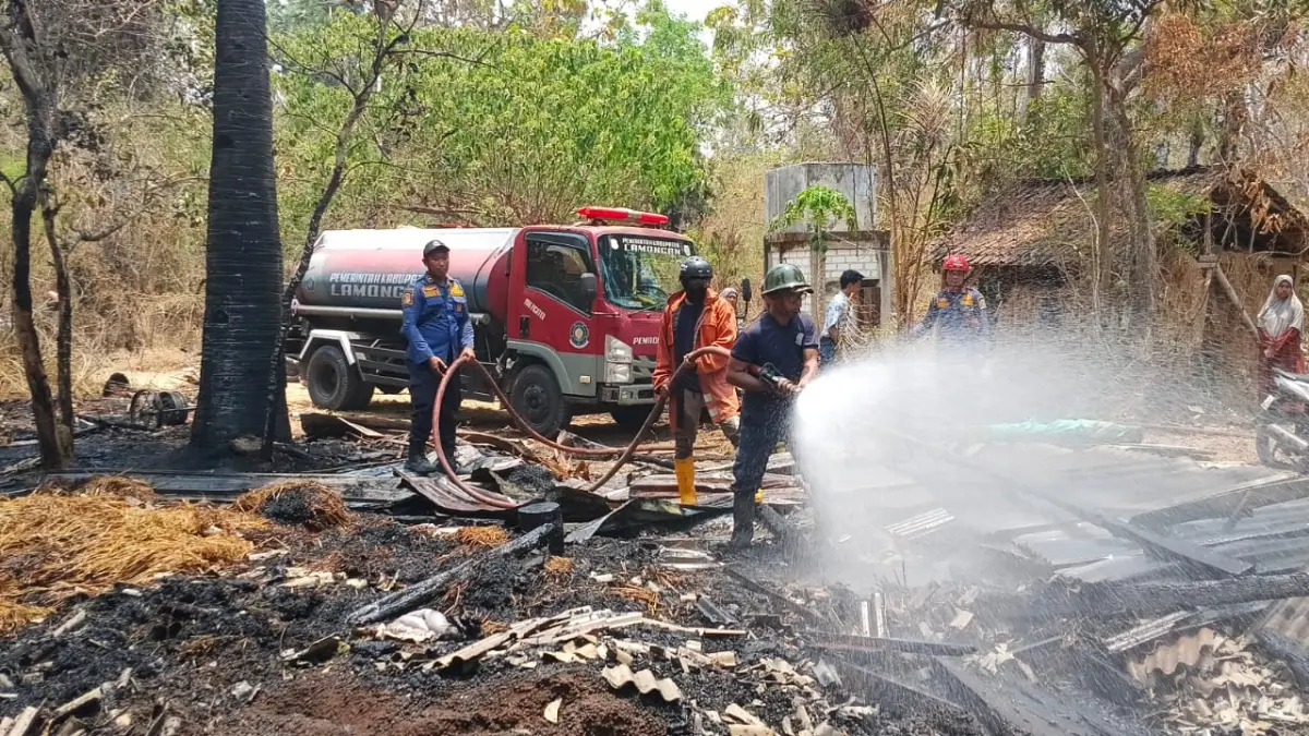 PEMADAMAN: Petugas menyemprotkan air ke kandang yang terbakar di Desa/Kecamatan Paciran.&nbsp;(Istimewa/Radar Lamongan)