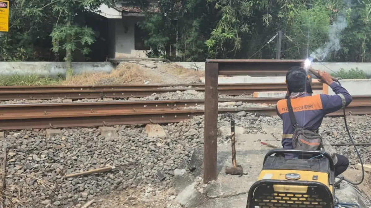 DITUTUP: Pekerja mengelas pintu agar pengendara tidak bisa melewati perlintasan sebidang.&nbsp;(Istimewa/Radar Lamongan)