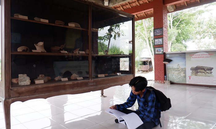 EDUKATIF: Pengunjung tengah membaca narasi temuan sejarah sembari mengamati deretan artefak yang dipajang di museum Desa Klinterejo. (foto Rizki Firmansyah)