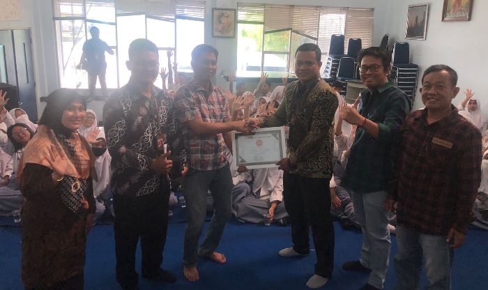 KENANGAN: Perwakilan guru dan pembimbing SMK Ketintang Surabaya menyerahkan suvenir kepada perwakilan manajeman JPRM. (foto Indah Oceananda)