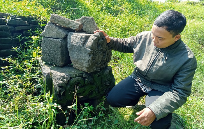 TERSISA: Pengunjung mengamati relief patung Shiwa, di Dusun Nglinguk, Desa/Kecamatan Trowulan.  (foto Putri Fadiyah for Radar Majapahit)