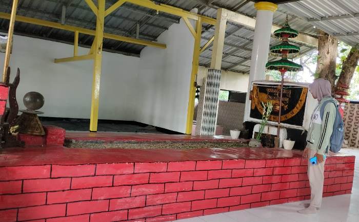 TAK BIASA: Salah satu pengunjung melihat kondisi Makam Panjang di Dusun Unggahan Desa/Kecamatan Trowulan, Kabupaten Mojokerto. (foto: Nadya Azzahra for Radar Majapahit)