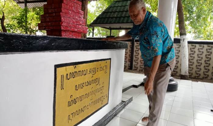 BERSEJARAH: Suwito menerjemahkan tulisan aksara jawa yang tertulis di atas batu di Makam Panjang yang terletak di Dusun Unggahan Desa/Kecamatan Trowulan. (foto: Putri Fadiyah for Radar Majapahit)
