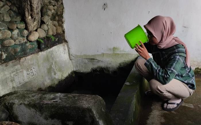 DIYAKINI BERKHASIAT: Pengunjung mengonsumsi air Sumber Towo di Dusun Unggahan, Desa/Kecamatan Trowulan, Kabupaten Mojokerto. (foto: Nadya Azzahra for Radar Majapahit)