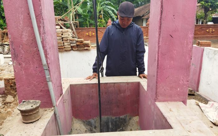 SUMBER AIR: Pengunjung mengamati sumber air di Sumur Sakti Gajah Mada, di Desa Beloh, Kecamatan Trowulan, Kabupaten Mojokerto. (foto: Moch. Khasib for Radar Majapahit)