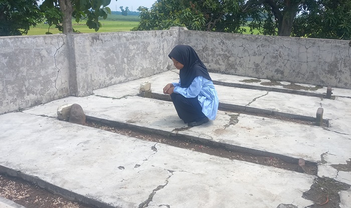 KERAMAT: Pengunjung mengamati empat makam yang dipercaya makam tandhak atau penari Jawa, di Desa Watesumpak, Kecamatan Trowulan, Kabupaten Mojokerto. (foto: Annisa for Radar Majapahit)