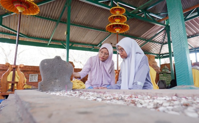 MENGENANG JASA: Pengunjung mengamati makam Tujuh Troloyo, di Dusun Sidodadi, Desa Sentonorejo, Kecamatan Trowulan, Kabupaten Mojokerto. (foto: Misbakhul Ulum for Radar Majapahit)