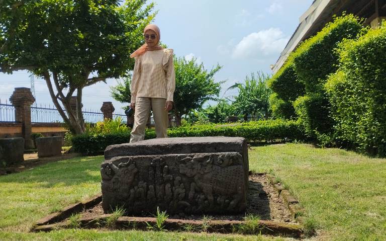 TEMUAN ARCA: Pengunjung melintas di depan arca berbentuk naga di Candi Minak Jinggo di Dusun Unggahan, Desa/Kecamatan Trowulan, Kabupaten Mojokerto. (foto Nadya Azzahra for Radar Majapahit)