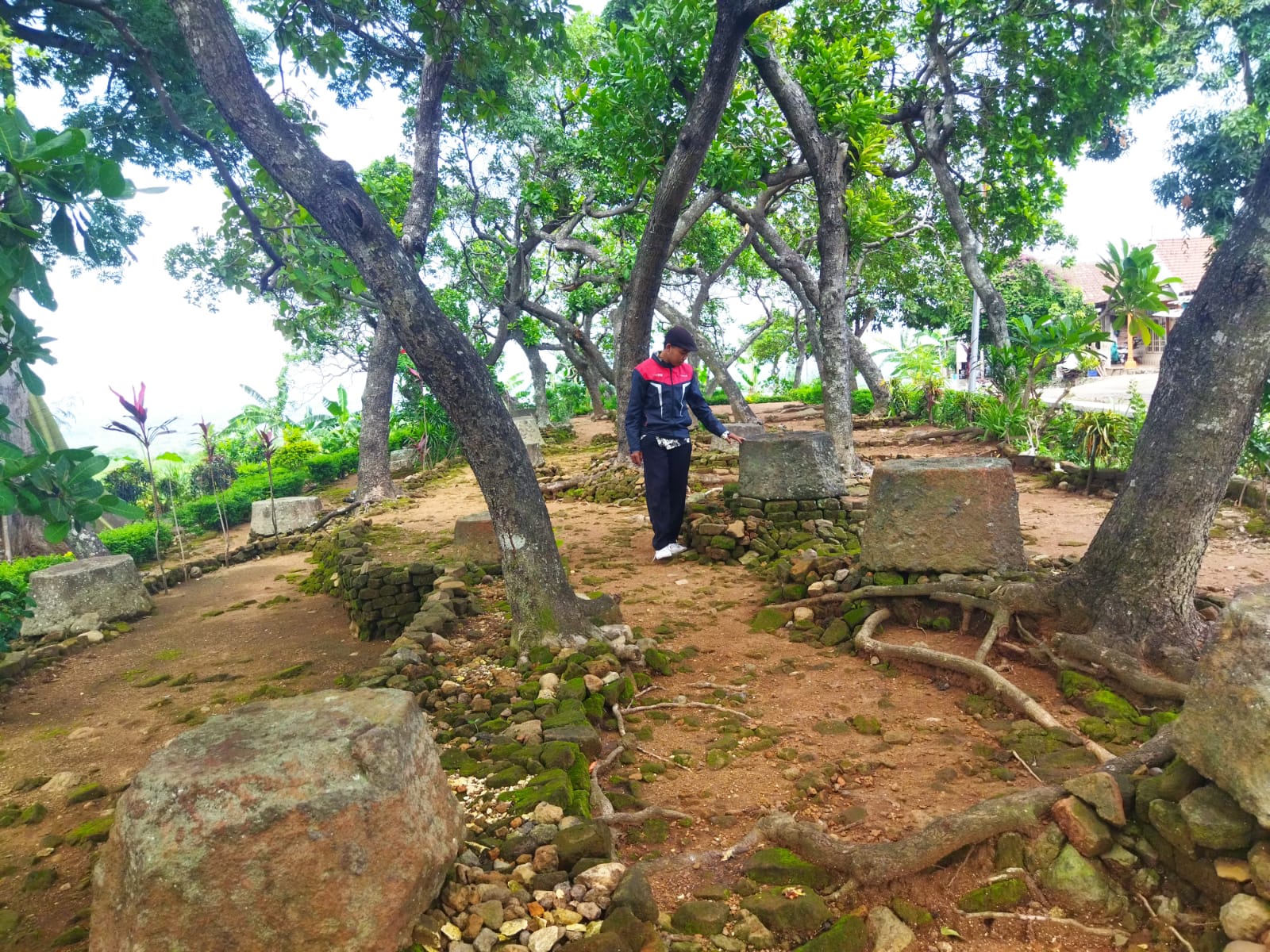 UNIK: Pengunjung mengamati batu umpak berbentuk trapesium berukuran cukup besar di Situs Umpak Lebak Jabung. (foto: Moch. Khasib for Radar Majapahit)