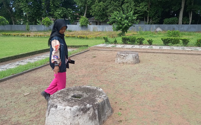 PENINGGALAN TERDAHULU: Pengunjung mengamati Situs Watu Umpak di Desa Sentonorejo, Kecamatan Trowulan, Kabupaten Mojokerto. (foto: Annisa for Radar Majapahit)