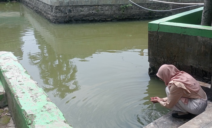 PENINGGALAN: Peziarah mengamati Kolam Buyuk tak jauh dari Makam Hasan Ibrahim, di Dusun/Desa Karang Kedawang, Kecamatan Sooko, Kabupaten Mojokerto. (foto: Laila Ramadani for Radar Mojokerto)