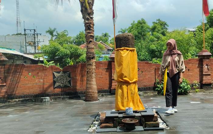 TEMPAT SAKRAL: Pengunjung melihat lingga yoni di depan pendapa Makam Ki Ageng Saloko Gading di Desa Seduri, Kecamatan Mojosari. (foto: Nadya Azzahra for Radar Majapahit)