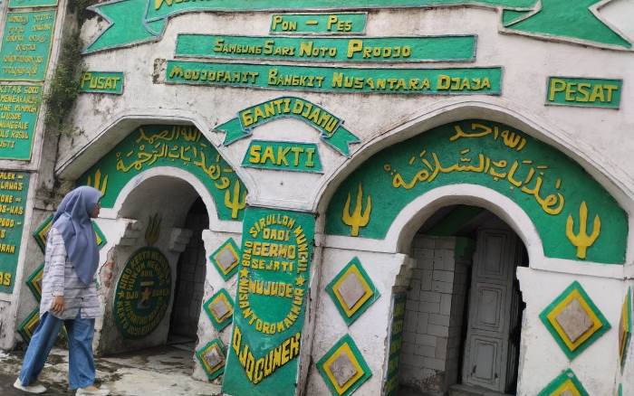 TAK BIASA: Pengunjung mengamati keunikan dinding pintu masuk Masjid Agung Wisnu Manunggal Rahmatullah di Desa Pekukuhan, Kecamatan Mojosari. (foto: Putri Fadiyah for Radar Majapahit)