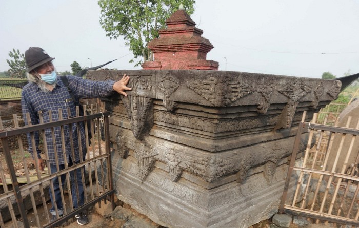 JEJAK ARKEOLOGIS: Arkeolog Ismail Lutfi menunjukkan angka tahun yang tertera di dinding yoni Situs Bhre Kahuripan, Desa Klinterejo, Kecamatan Sooko, Kabupaten Mojokerto.