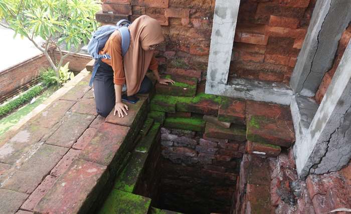 TAK BERFUNGSI: Pengunjung melihat kondisi sumur di area Candi Sumur, di Dusun Candi Pari Wetan, Desa Candi Pari, Kecamatan Porong, Kabupaten Sidoarjo. (foto: Reza Firman for Radar Majapahit)