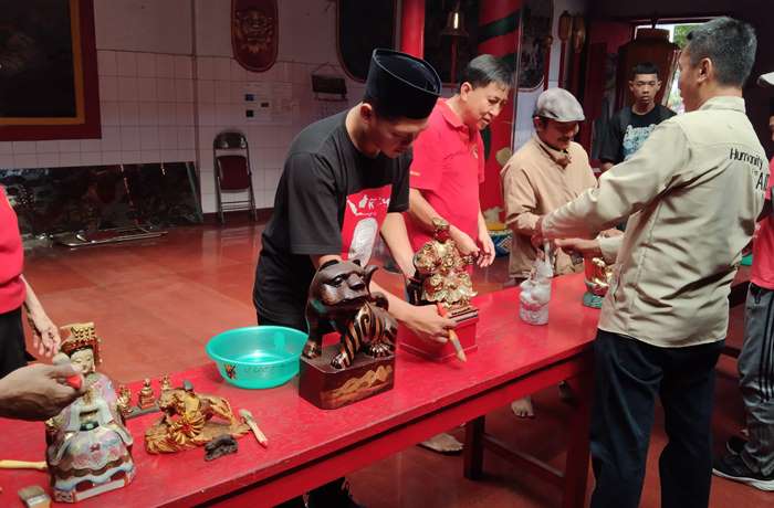 TOLERANSI: Komunitas Gusdurian Mojokerto membantu memandikan patung para dewa di Kelenteng Hok Sian Kiong Kota Mojokerto, Minggu (4/2). (foto: Bryan Noer for Radar Majapahit).