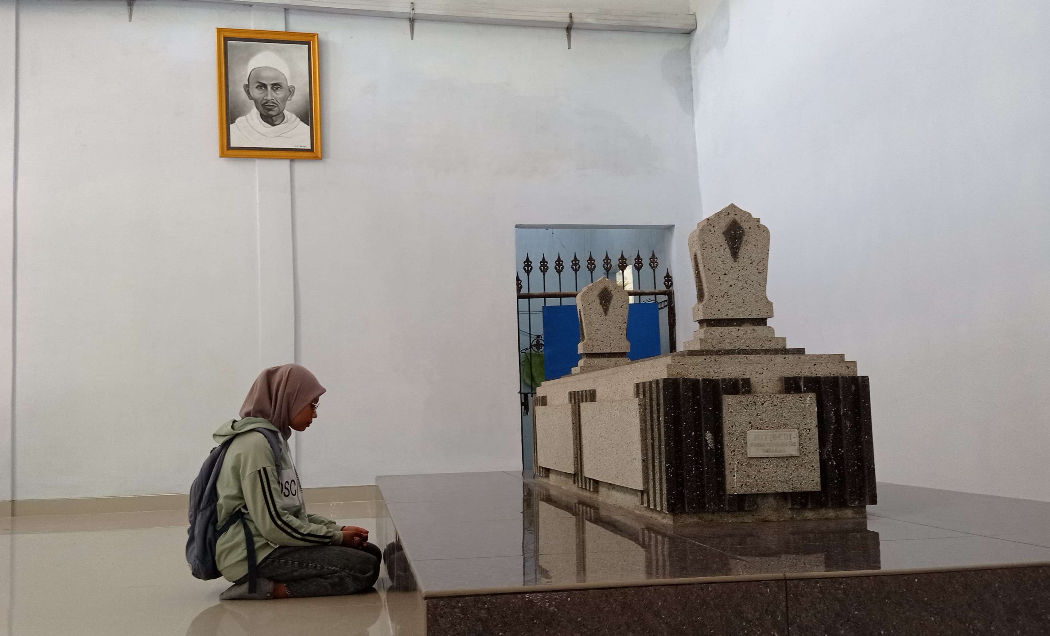 KHUSUK: Peziarah berdoa di depan Makam Mbah Musthofa di Dusun Kedung Sumur, Desa Canggu, Kecamatan Jetis, Kabupaten Mojokerto. (foto: Wilda Mifta for Radar Majapahit)