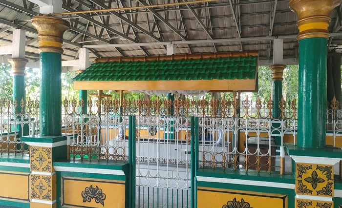DIRAWAT: Makam Mbah Sentono di Dusun Ngabar, Desa Ngabar, Kecamatan Jetis, Kabupaten Mojokerto dilindungi pagar pembatas dominasi warna hijau dan kuning. (foto: Misbakhul Ulum for Radar Majapahit)