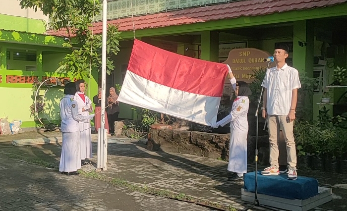 BERKIBAR: Pengibaran bendera merah putih dalam upacara memperingati HPN 2024 di halaman sekolah DQ, Kelurahan Wates, Kecamatan Magersari, Kota Mojokerto. (foto: Misbakhul Ulum for Radar Majapahit)