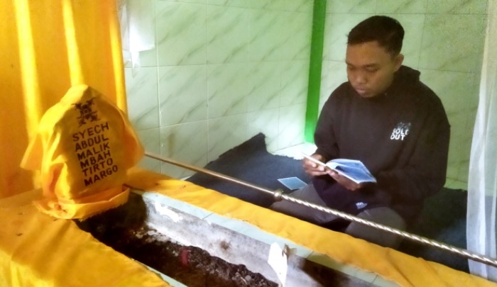 KHUSUK: Peziarah membaca doa di Makam Mbah Margo di Desa Karangjeruk, Kecamatan Jatirejo, Kabupaten Mojokerto. (foto: Moch. Khasib for Radar Majapahit)