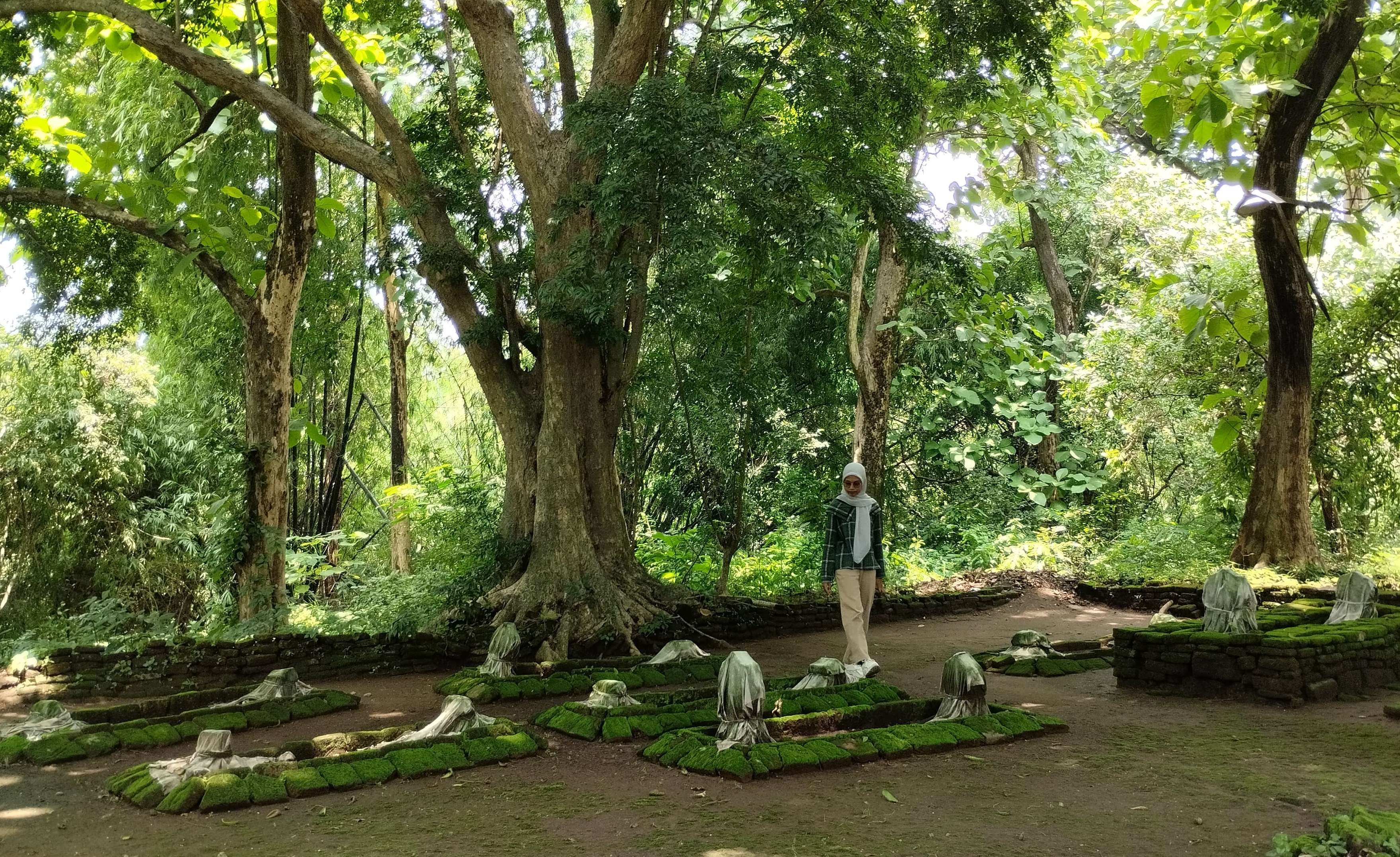 TERAWAT: Peziarah mengamati sejumlah makam yang terdapat di area kompleks pemakaman, di Desa Sumberwono, Kecamatan Bangsal, Kabupaten Mojokerto. (Foto: Nadya Azzahra for Radar Majapahit)