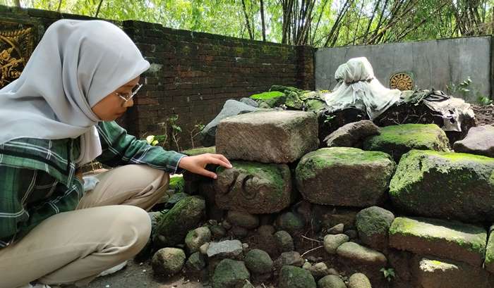 CAGAR BUDAYA: Peziarah melihat temuan relief berada di dekat Makam Tumenggung Prawiro Seno, di Desa Sumberwono, Kecamatan Bangsal, Kabupaten Mojokerto. (foto: Nadya Azzahra for Radar Majapahit)