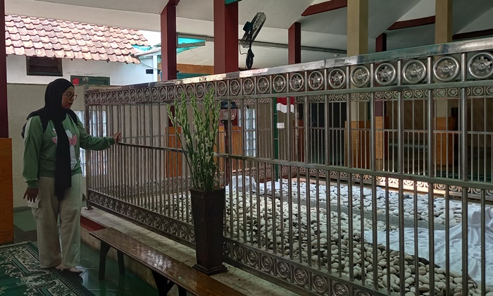 MENGENANG: Pengunjung mengamati Makam KH Achyat Chalimy di Kelurahan Miji, Kecamatan Kranggan, Kota Mojokerto. (foto Laila Ramadani for Radar Majapahit).