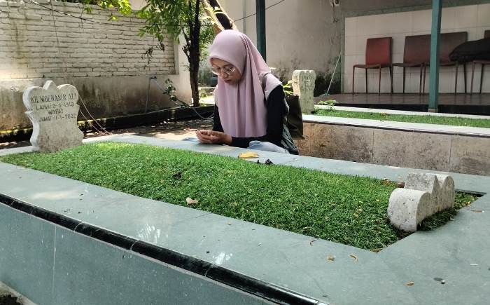 MENGENANG: Peziarah berdoa di Makam KH Moenasir Ali, di Dusun/Desa Pekukuhan, Kecamatan Mojosari, Kabupaten Mojokerto. (foto: Nadya Azzahra for Radar Majapahit)