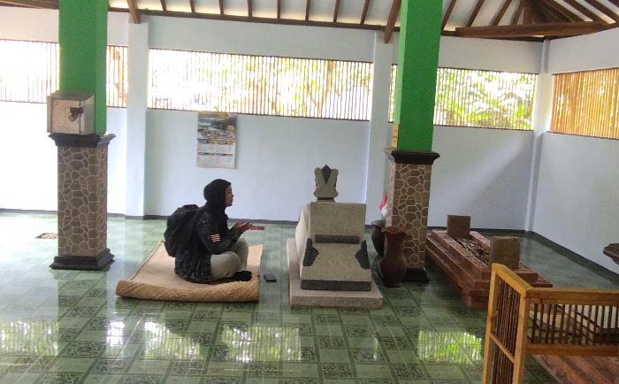 MENGENANG: Peziarah berdoa di Makam Mbah Djatmiko, di Dusun Bacem, Desa Bening, Kecamatan Gondang, Kabupaten Mojokerto. (foto Annisa Fadilah for Radar Majapahit).