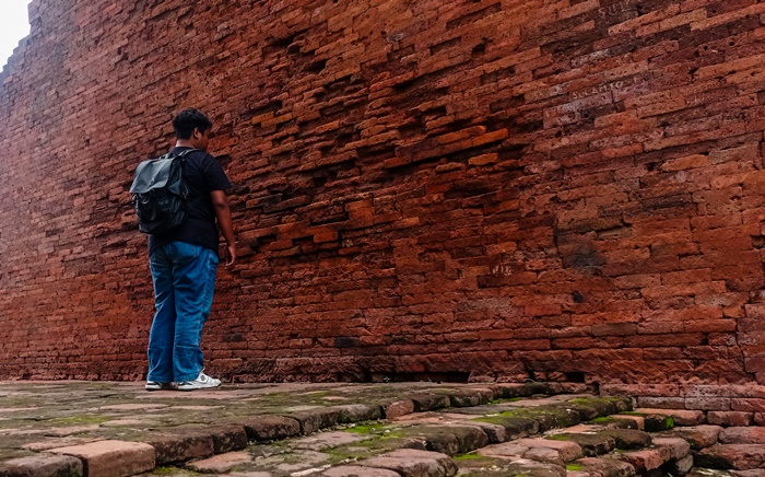 DAYA TARIK: Pengunjung mengamati tembok Gapura Wringin Lawang, di Jatipasar, Kecamatan Trowulan, Kabupaten Mojokerto. (foto: Awaludin Ibnu for Radar Majapahit)