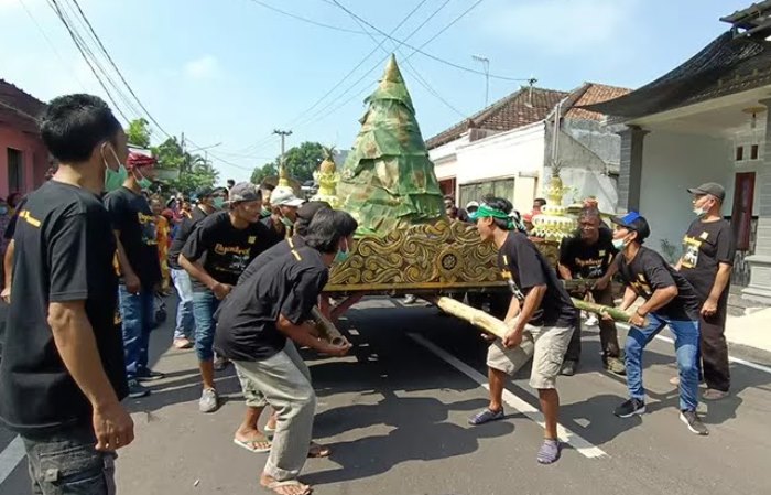 DILESTARIKAN: Warga mengarak gunungan nasi tumpeng dalam tradisi nyadran di Lingkungan Kemasan, Kelurahan Blooto, Kecamatan Prajurit Kulon.