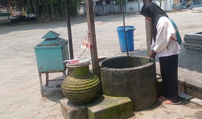 SUMBER AIR: Pengunjung mengamati sumur tua Troloyo di Dusun Sidodadi, Desa Sentonorejo, Kecamatan Trowulan, Kabupaten Mojokerto. (foto: Noval Perdana for Radar Majapahit)