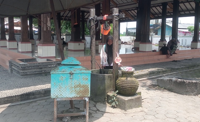 BERSEJARAH: Pengunjung sedang mengambil air di sumur tua Troloyo, Dusun Sidodadi, Desa Sentonorejo, Kecamatan Trowulan, Kabupaten Mojokerto. (foto: Noval Perdana for Radar Majapahit)
