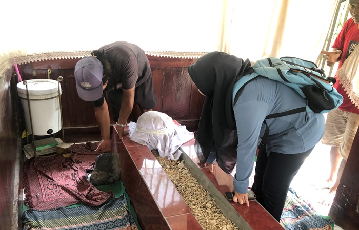BUKTI: Abdul Rouf (kiri) jupel makam menunjukkan letak batu yang menjadi awal ditandainya Makam Syaikh Mahdum Syarfiin, di Desa Kedungbocok, Tarik, Sidoarjo. (Foto: Bryan Noer for Radar Majapahit).