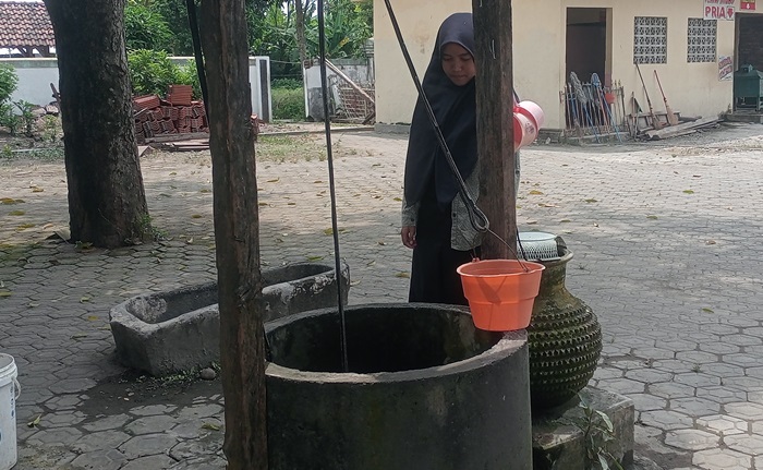 SEJARAH: Pengunjung mengamati sumur kuno di kompleks Makam Troloyo, di Dusun Sidodadi, Desa Sentonorejo, Kecamatan Trowulan, Kabupaten Mojokerto. (foto: Laila Ramadani for Radar Majapahit).