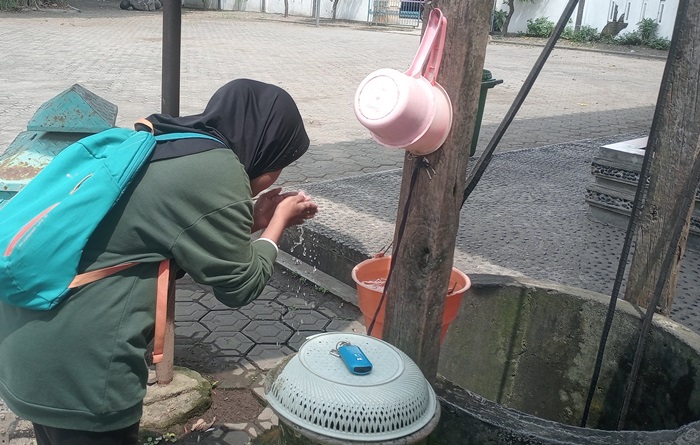 SEGAR: Pengunjung sedang cuci muka di sumur kuno Makam Troloyo, di Dusun Sidodadi, Desa Sentonorejo, Kecamatan Trowulan, Kabupaten Mojokerto. (foto: Lailatul Mukaromah for Radar Majapahit).