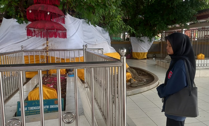TERJAGA: Peziarah mengamati Makam Temenggung Satim Singomoyo di kompleks Makam Troloyo, Desa Sentonorejo, Kecamatan Trowulan, Kabupaten Mojokerto. (foto: Annisa Fadilah for Radar Majapahit)