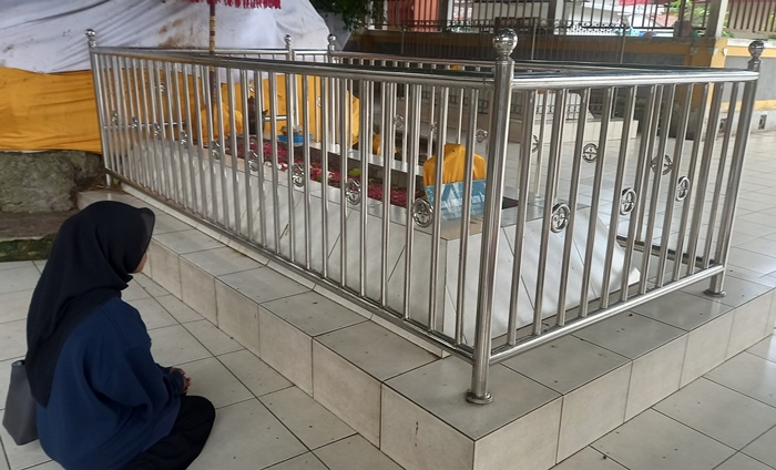 TOKOH PENTING: Peziarah berdoa di Makam Temenggung Satim Singomoyo di kompleks Makam Troloyo, Desa Sentonorejo, Kecamatan Trowulan, Kabupaten Mojokerto. (foto: Annisa Fadilah for Radar Majapahit)